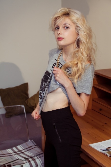 Tiny titted blonde Angelik peels off her clothes to spread naked at her desk