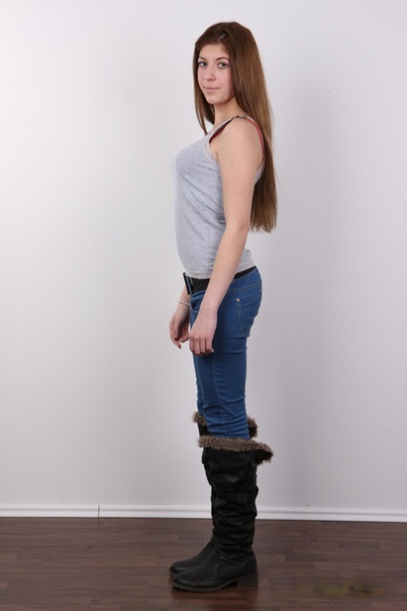 Pretty girl Adriana stands fully clothed before getting completely naked