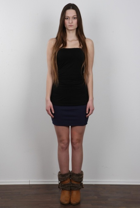 Long haired girl takes off all her clothes to model in the nude