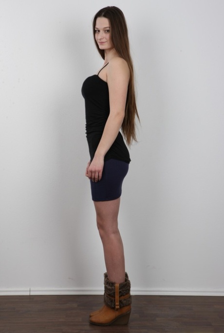 Long haired girl takes off all her clothes to model in the nude
