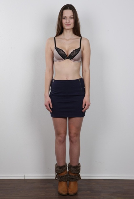 Long haired girl takes off all her clothes to model in the nude
