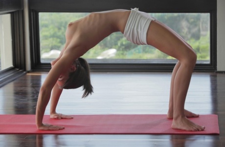 Skinny girl strips of her shorts to meditate and practice yoga in the nude
