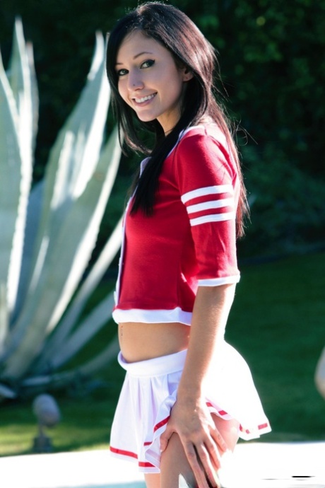 Brunette cheerleader Catie Minx exposes her tight ass near a swimming pool