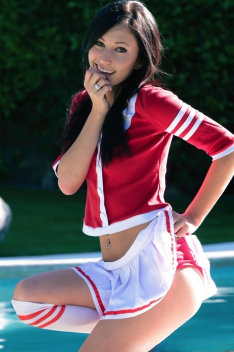 Brunette cheerleader Catie Minx exposes her tight ass near a swimming pool