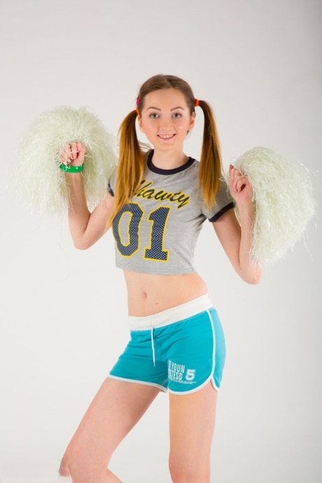 Petite teen Tina puts down pompoms before showcasing bald slit in the nude