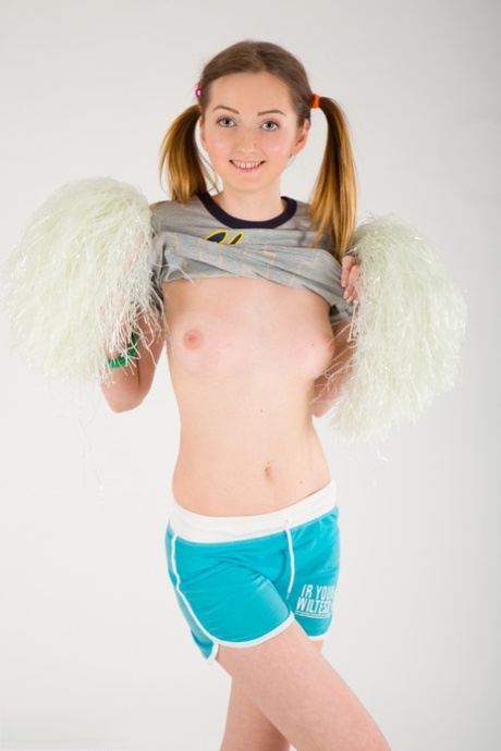 Petite teen Tina puts down pompoms before showcasing bald slit in the nude