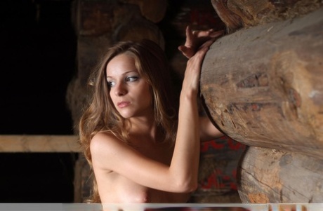 Totally naked girl Conny strikes great poses inside a log outbuilding