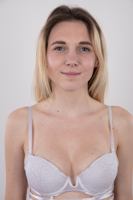 Blonde teen crosses her legs after getting completely naked on a stool