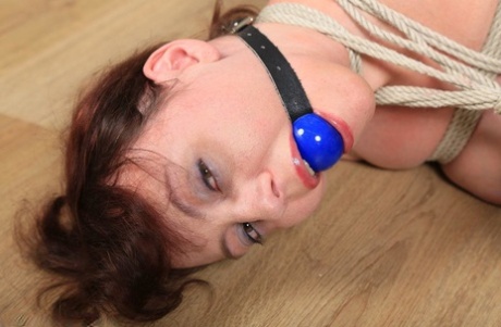 Caucasian MILF is ball gagged and tied up while topless in sexy stockings