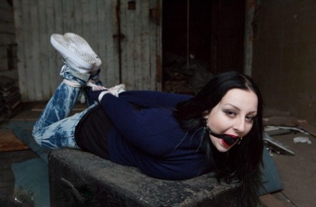 Two white girls are hogtied and ball gagged in sweaters and jeans