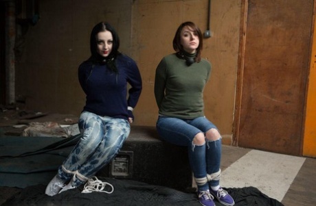 Two white girls are hogtied and ball gagged in sweaters and jeans