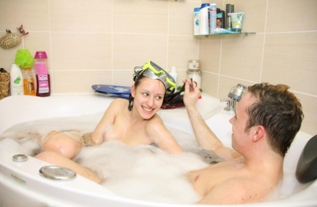Cute teen engages in oral sex while wearing flippers in a bathtub