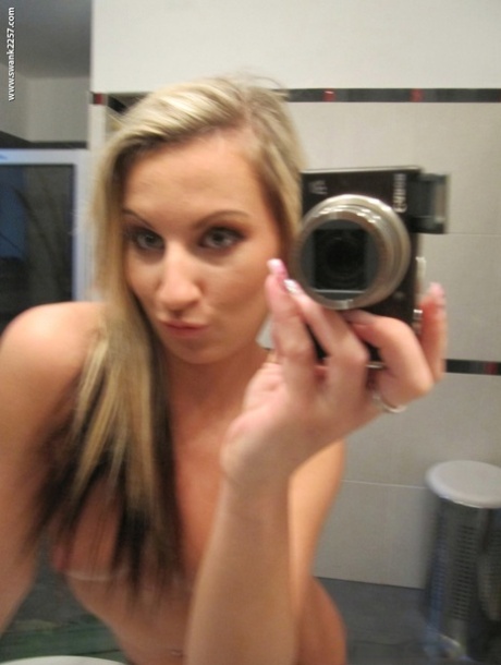 Blonde amateur gets totally naked while taking self shots in a bathroom mirror