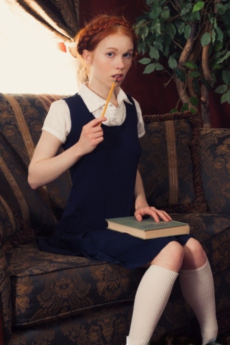 Young looking redhead Dolly Little gets naked in white socks and Mary Jane's