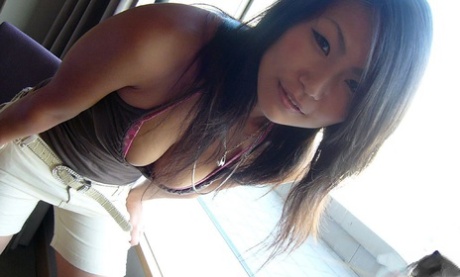 Japanese teen Asami uncovers her perky tits while getting in a bathtub