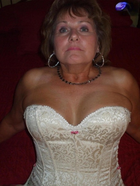 Mature woman models non nude in a corset and nylons with garters