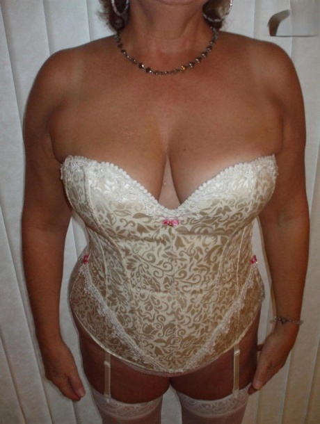 Mature woman models non nude in a corset and nylons with garters