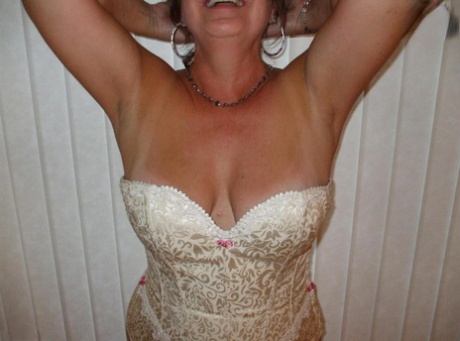 Mature woman models non nude in a corset and nylons with garters