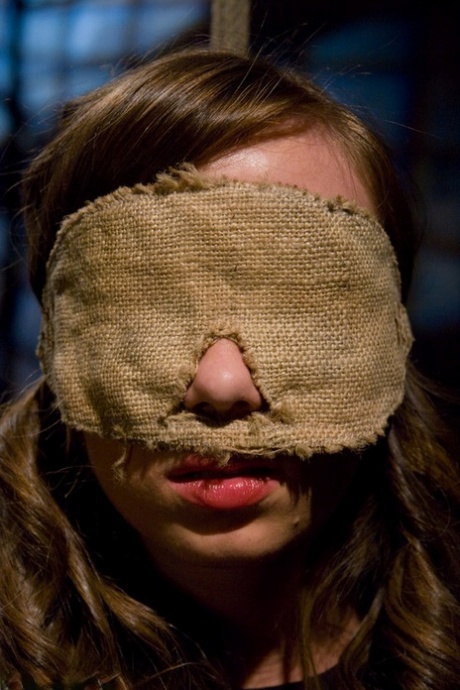 Pretty girl is blindfolded and ball gagged during sex play in a dungeon