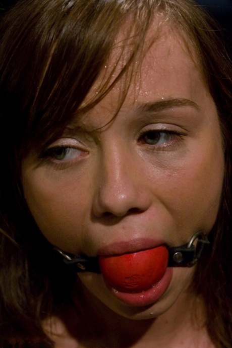 Pretty girl is blindfolded and ball gagged during sex play in a dungeon