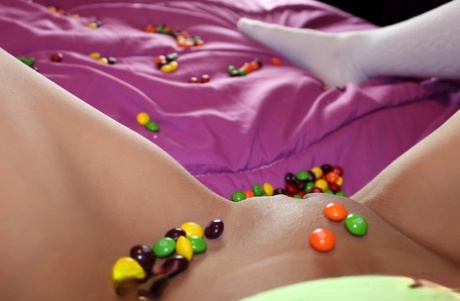 Young girl Andi Land covers herself in candy while showing her tits and snatch