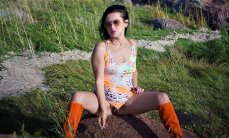 Mature woman Diana Ananta wears knee-high boots during no panty upskirt action