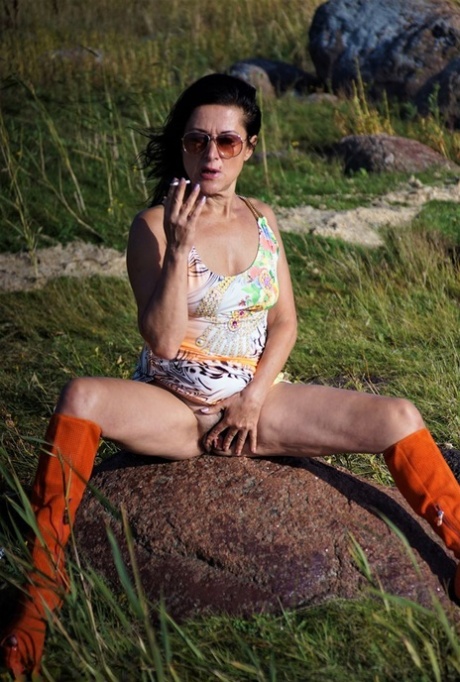 Mature woman Diana Ananta wears knee-high boots during no panty upskirt action