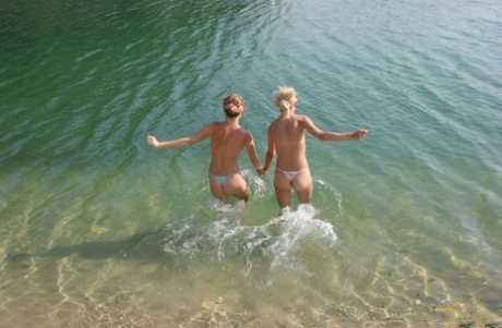 Blonde girls hump each other while going topless on a private beach
