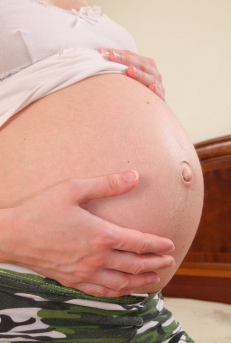 Solo girl shows her heavily pregnant belly before masturbating with a vibrator