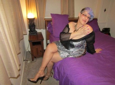 Old woman Bunny Gram shows her hose covered pussy on a bed in pointy shoes
