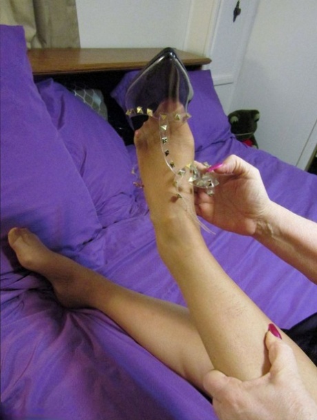 Old woman Bunny Gram shows her hose covered pussy on a bed in pointy shoes
