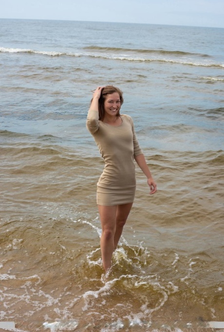 Tall teen Mina hangs wet clothes to dry while posing nude on a beach