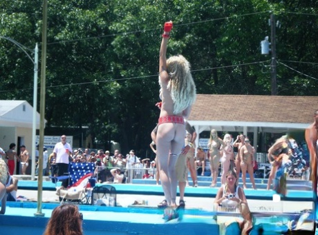 Female strippers get naked on an outdoor stage at a clothing optional club