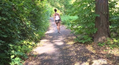 Short taken girl Ali Bordeaux takes a pee while walking on a path in the woods