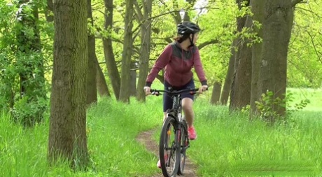Solo girl Antonia Sainz squats for a pee while biking on a path in the woods