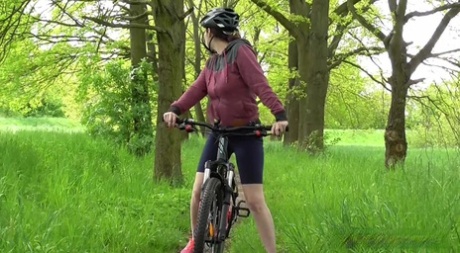Solo girl Antonia Sainz squats for a pee while biking on a path in the woods