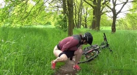 Solo girl Antonia Sainz squats for a pee while biking on a path in the woods