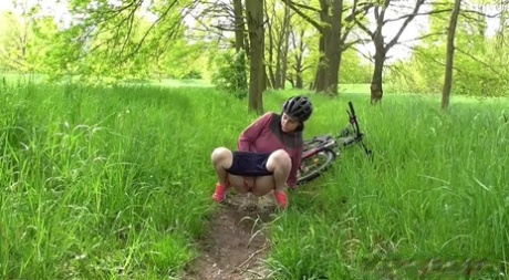 Solo girl Antonia Sainz squats for a pee while biking on a path in the woods
