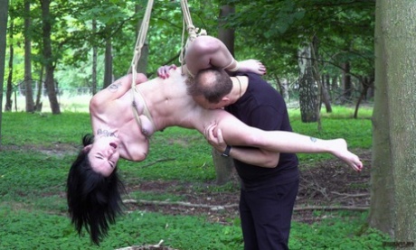 Naked brunette Crystal Cherry gives a BJ after being flogged in the woods