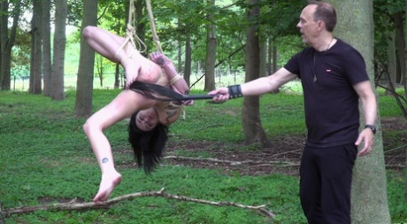 Naked brunette Crystal Cherry gives a BJ after being flogged in the woods