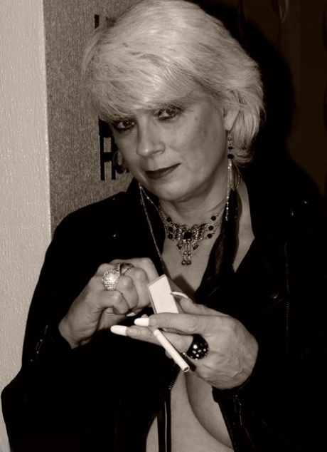 Older blonde Dimonty shows her tits and snatch while smoking a cigarette