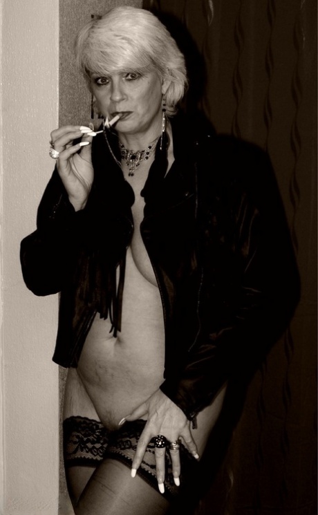 Older blonde Dimonty shows her tits and snatch while smoking a cigarette