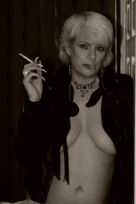 Older blonde Dimonty shows her tits and snatch while smoking a cigarette
