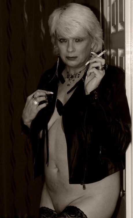 Older blonde Dimonty shows her tits and snatch while smoking a cigarette