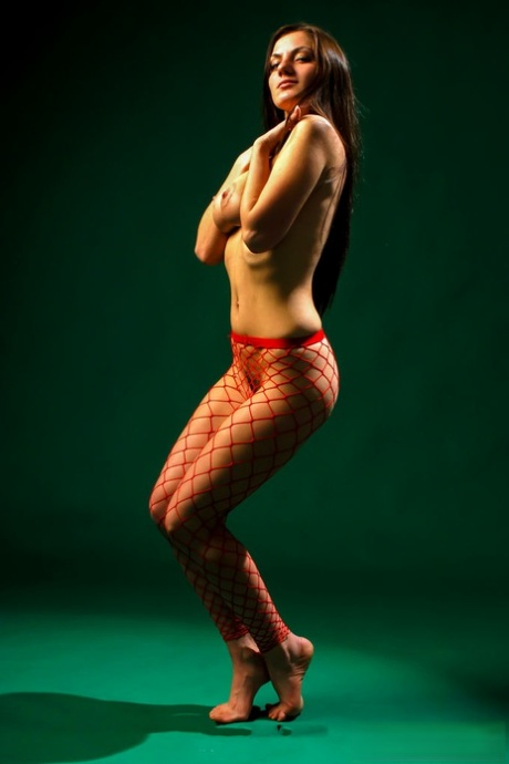 18-year-old beauty Tia M dons fishnet pantyhose during a nude modelling gig