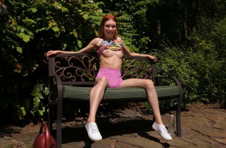 Redheaded teen Jessica Marie pees on a patio bench in white running shoes