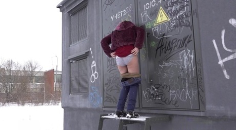 Caucasian girl Jessy shows her bare ass while peeing on snow-covered ground