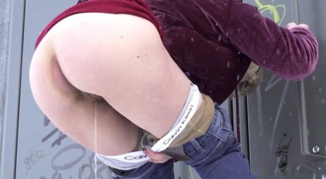 Caucasian girl Jessy shows her bare ass while peeing on snow-covered ground