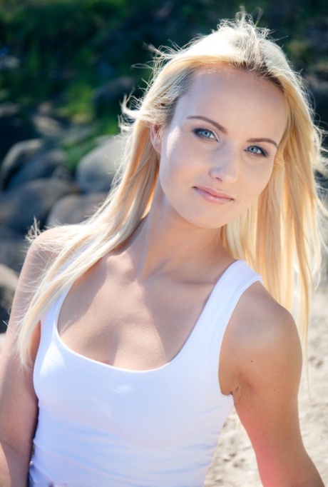Blonde teen Sophia Sonne gets naked on a rocky shoreline in running shoes