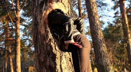 Sexy girl Katy Dee leans back against a tree to take a badly needed pee